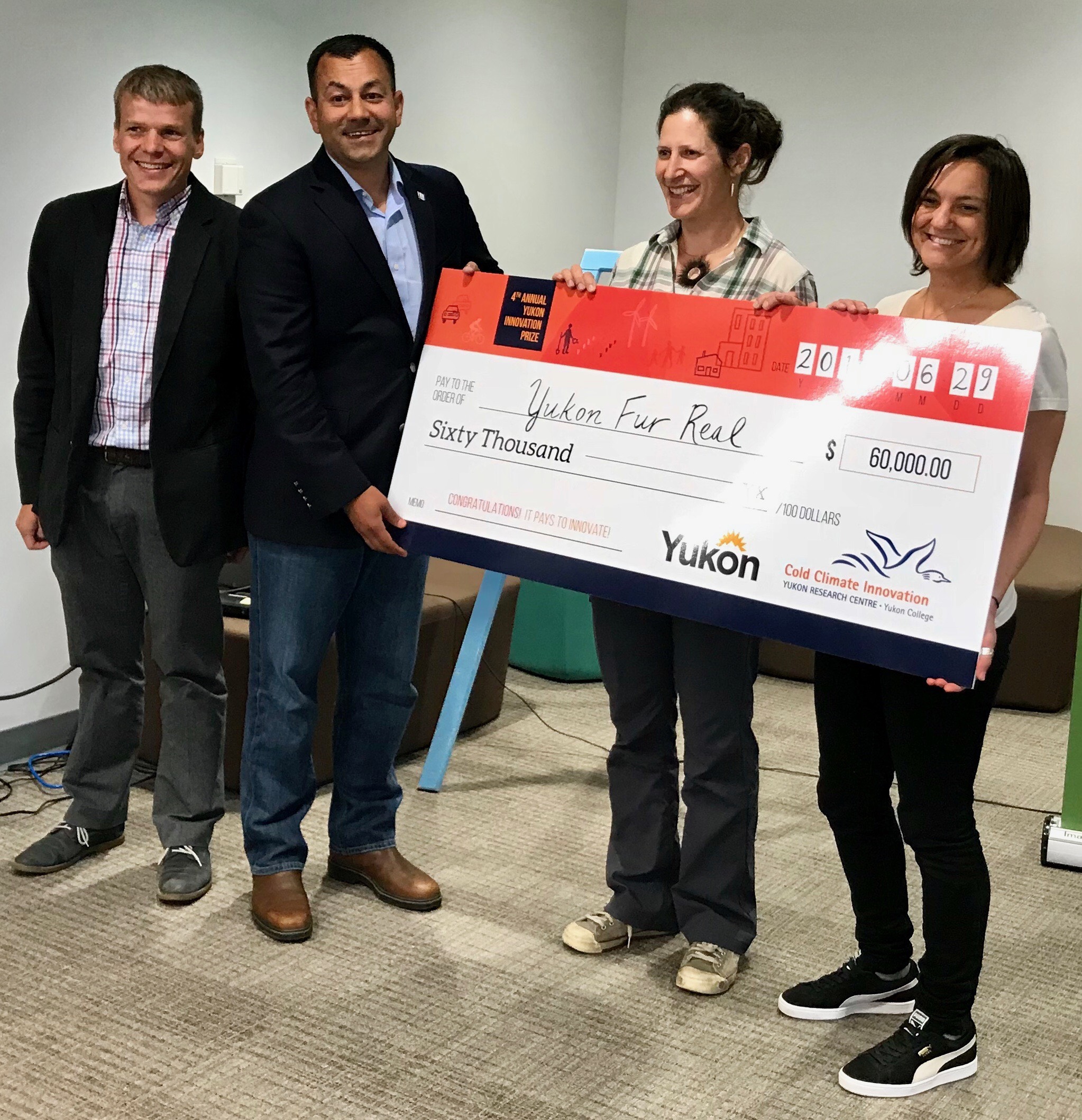 Harry Borlase and Minister Ranj Pillai present the $60,000 YIP cheque to Yukon Fur Real members Lisa Preto and Misha Donohoe.