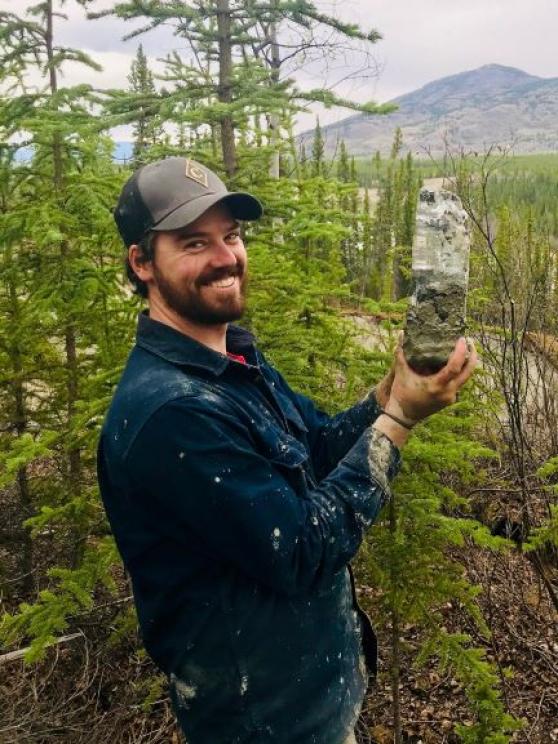 Louis-Phillipe Roy holds up a permafrost core outdoors