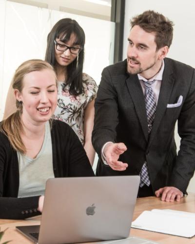 Students and instructor looking at a laptop