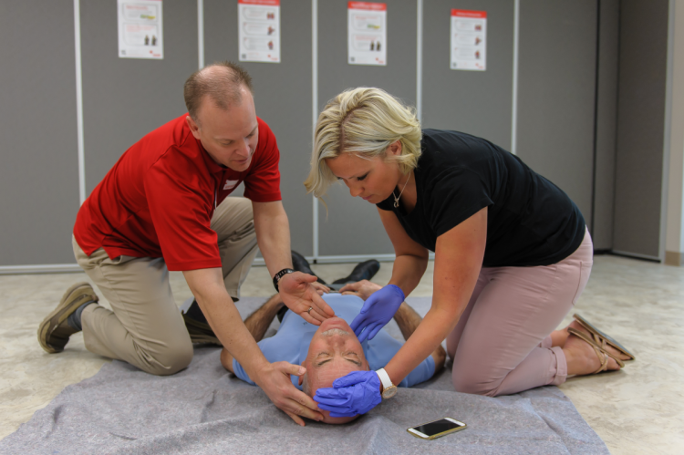 Person helping instruct a student on first aid.