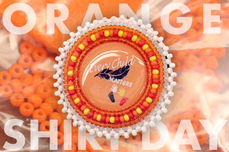 An orange, yellow, and white beaded pin that says "Every Child Matters" in the centre. The background is a bag of orange beads.