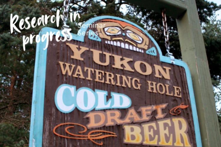Wood sign that says "Yukon Watering Hole - Cold Draft Beer"