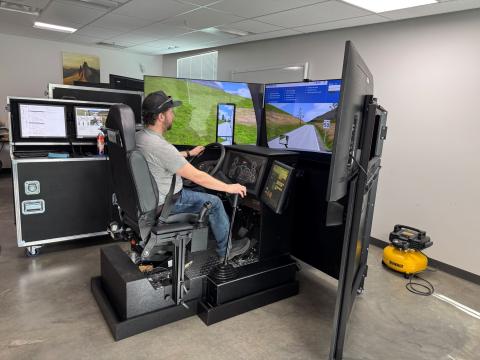 man sits in simulator driving a commercial truck