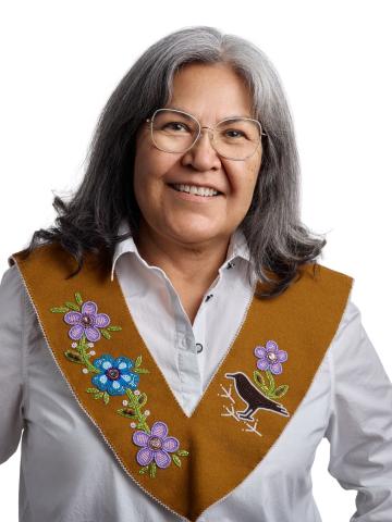 first nations woman in traditional stole and white blouse smiling