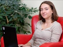 Girl sitting in a red chair with a computer on her lap