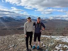 two men standing on top of a mountain