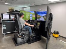 man sits in simulator driving a commercial truck