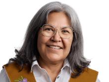 first nations woman in traditional stole and white blouse smiling